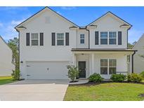 Charming two-story home with a well-maintained lawn, attached garage and inviting front porch at 625 Heritage Downs Dr., Conway, SC 29526