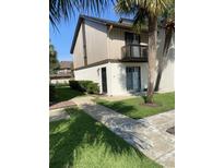 Charming two-story condo with a private balcony, lush lawn, and mature palm trees at 10200 Lake Shore Dr. # 4, Myrtle Beach, SC 29572