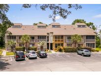 Inviting condo complex with brick facade, palm trees, and ample parking, perfect for coastal living at 1356 Glenns Bay Rd. # A202, Surfside Beach, SC 29575