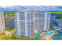 Stunning aerial view of the white SeaWatch Resort condo building, pools, landscaping and parking at 161 Sea Watch Dr. # 601, Myrtle Beach, SC 29572