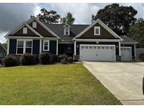 Charming one-story home features a well-maintained lawn and a two-car garage with carriage doors at 177 Board Landing Circle, Conway, SC 29526