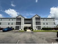 Condo building with symmetrical facade and neatly kept landscaping at 1980 Bent Grass Dr. # F, Surfside Beach, SC 29575