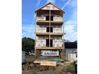 New four-story construction showing lumber and plywood against a blue sky at 211B 15Th Ave. S, Surfside Beach, SC 29575