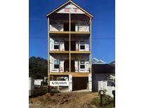 Three-story home under construction, showcasing the framing and initial stages of development under a clear blue sky at 211B 15Th Ave. S, Surfside Beach, SC 29575