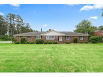 Charming brick home with a lush green lawn, manicured hedges, and classic shutters on a sunny day at 316 Oliver St., Marion, SC 29571