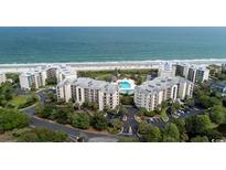 Aerial view of oceanfront condos with a pool, beautiful landscaping and beach access at 341 South Dunes Dr. # C-34, Pawleys Island, SC 29585