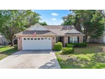 Charming brick home featuring an attached garage, a well-maintained lawn, and manicured landscaping at 4196 Ravenwood Dr., Little River, SC 29566
