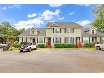 Inviting exterior view of a townhouse featuring a well-manicured lawn and ample parking at 4840 Moss Creek Loop # 38, Murrells Inlet, SC 29576