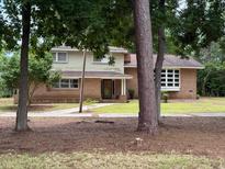 Two-story home with brick and siding exterior surrounded by mature trees at 4909 Yaupon Circle, Myrtle Beach, SC 29575