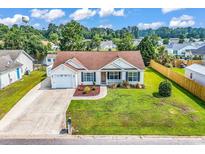 Charming single-story home with a well-manicured lawn, attached garage, and welcoming front porch at 5031 Medieval Dr., Conway, SC 29526