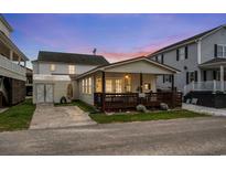 Charming home featuring a lovely front porch and a well-maintained yard, set against a colorful dusk sky at 6001-1453 S Kings Hwy., Myrtle Beach, SC 29575