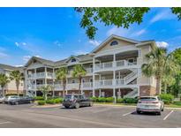 A beautiful three-story condo building with palm trees and a well-maintained parking lot at 6015 Catalina Dr. # 732, North Myrtle Beach, SC 29582