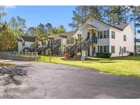 Well-maintained condos with green lawns and exterior stairs leading to upper units at 820 Fairway Dr. # 1502Hh, Longs, SC 29568