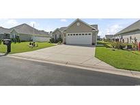 Charming single-story home featuring a well-manicured lawn and a spacious two car attached garage at 1068 Lizzie Ln., Surfside Beach, SC 29575