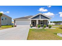Charming single-story home with a well-manicured lawn, covered porch, and attached two-car garage at 125 Foxford Dr., Conway, SC 29526