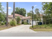 Charming single-story home with a red tile roof, mature landscaping, and a spacious driveway at 1501 Harbor Dr., North Myrtle Beach, SC 29582
