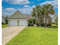 Charming one-story home featuring a two-car garage, well-manicured lawn, and beautiful palm trees at 1635 Southwood Dr., Surfside Beach, SC 29575