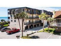 Coastal condo complex with covered parking, lush palms, and ocean views from private balconies at 201 76Th Ave. N # D-3, Myrtle Beach, SC 29572