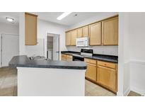 Galley kitchen featuring wood cabinets, stainless steel sink and black appliances at 2061 Silvercrest Dr. # 7E, Myrtle Beach, SC 29579