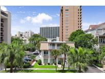 Charming multi-story villa with palm trees, manicured lawn, and white picket fence; coastal living at its finest at 211 76Th Ave. N # A3, Myrtle Beach, SC 29572