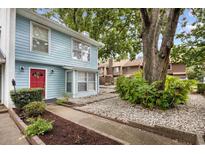 Charming two-story home features a bright exterior, red door, beautiful landscaping, and mature trees at 308 76Th Ave. N # 5, Myrtle Beach, SC 29572