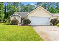 Charming yellow single-story home with a manicured lawn and attached two-car garage at 396 Mckendree Ln., Myrtle Beach, SC 29579