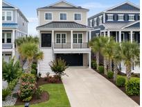 Two-story home featuring a 1-car garage, a manicured lawn, and lush landscaping, and a metal roof at 433 Saint Julian Ln., Myrtle Beach, SC 29579