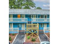 Charming blue exterior building with private balconies and well-maintained landscaped walkway at 601 Putters Ln. # H209, Little River, SC 29566