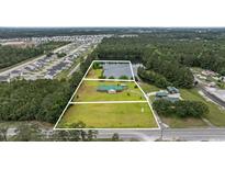 Stunning aerial view of a home with a pond, mature trees, and large lot at 1342 Highway 90, Conway, SC 29526