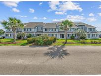 Charming condo complex with well-manicured landscaping and palm tree accents under a bright blue sky at 1890 Colony Dr. # 17L, Surfside Beach, SC 29575