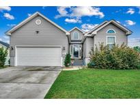 Charming home featuring gray siding, well-maintained lawn, and an attached two-car garage at 2461 Summerhaven Loop, Conway, SC 29527