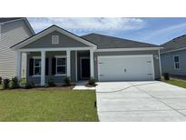 Charming single-story home with a two-car garage, manicured lawn, and inviting entrance at 3333 Sw Wood Stork Dr., Ocean Isle Beach, NC 28469