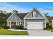 Charming single-Gathering home with blue siding, well-manicured lawn, and two-car garage in a friendly neighborhood at 341 Bahama Dr., Murrells Inlet, SC 29576