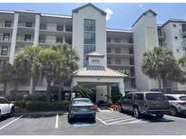 Elegant multi-story building with lush landscaping, covered entrance, and ample parking space at 371 S Dunes Dr., Pawleys Island, SC 29585