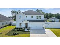This is a charming two-story home featuring a pristine white exterior, well-manicured lawn, and a spacious two-car garage at 4115 Bayhill St., Myrtle Beach, SC 29579