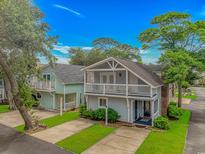 Charming coastal home featuring double balconies, lush landscaping, and a well-maintained lawn at 4309 Beverly Ct., North Myrtle Beach, SC 29582