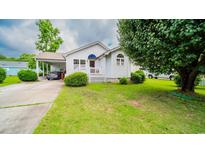 Charming home features a manicured lawn and attached carport at 434 Deer Path, Calabash, NC 28467