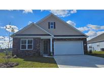 Charming single-Gathering home showcasing stone accents, a two-car garage and well-manicured lawn at 446 Clear Lake Dr., Conway, SC 29526
