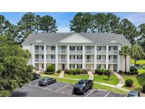 Three-story condominium building featuring private balconies, green landscaping, and convenient parking at 5040 Windsor Green Way # 204, Myrtle Beach, SC 29579