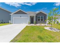 Charming single-story home with a two-car garage and well-manicured lawn and landscaped front yard at 506 Hogwart Ln., Longs, SC 29568
