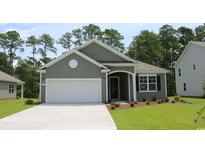 Charming one-story home features a landscaped yard, gray siding, and a two-car garage at 733 Doonbeg Ct., Conway, SC 29526