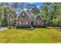 Charming brick home with a well-manicured lawn and lush landscaping, exuding curb appeal at 904 Moultrie Circle, Myrtle Beach, SC 29588