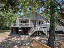 Charming raised beach house with gray siding, white railings, and inviting front porch at 1022 Waccamaw Dr., Conway, SC 29526