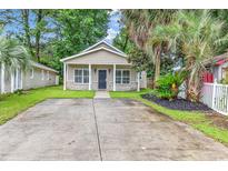 Charming single-story home featuring a well-manicured lawn, symmetrical design, and welcoming front porch at 1636 Stuart Square Circle, Myrtle Beach, SC 29577