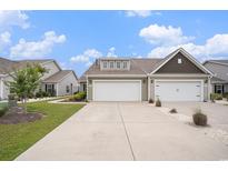 Charming home featuring a two-car garage and well-manicured lawn, offering great curb appeal at 1807 Berkley Village Loop, Myrtle Beach, SC 29579