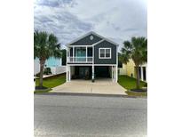 Stunning raised beach home featuring a covered porch, ample parking, and beautiful landscaping at 1961 24Th Ave. N, North Myrtle Beach, SC 29582