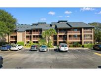 Coastal condominiums with wooden balconies surrounded by lush landscaping and ample parking at 223 Maison Dr. # 14D, Myrtle Beach, SC 29572