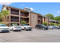 Charming condo building featuring tan siding, screened-in porches, and convenient parking at 223 Maison Dr. # C-13, Myrtle Beach, SC 29572