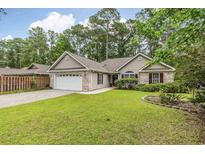 Charming home with well-manicured lawn, brick accents, attached garage, and lush landscaping at 24 Gate 7, Carolina Shores, NC 28467