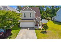 Charming two-story home with a well-manicured lawn, attached garage, and inviting front entrance at 309 Foxpath Loop, Myrtle Beach, SC 29588